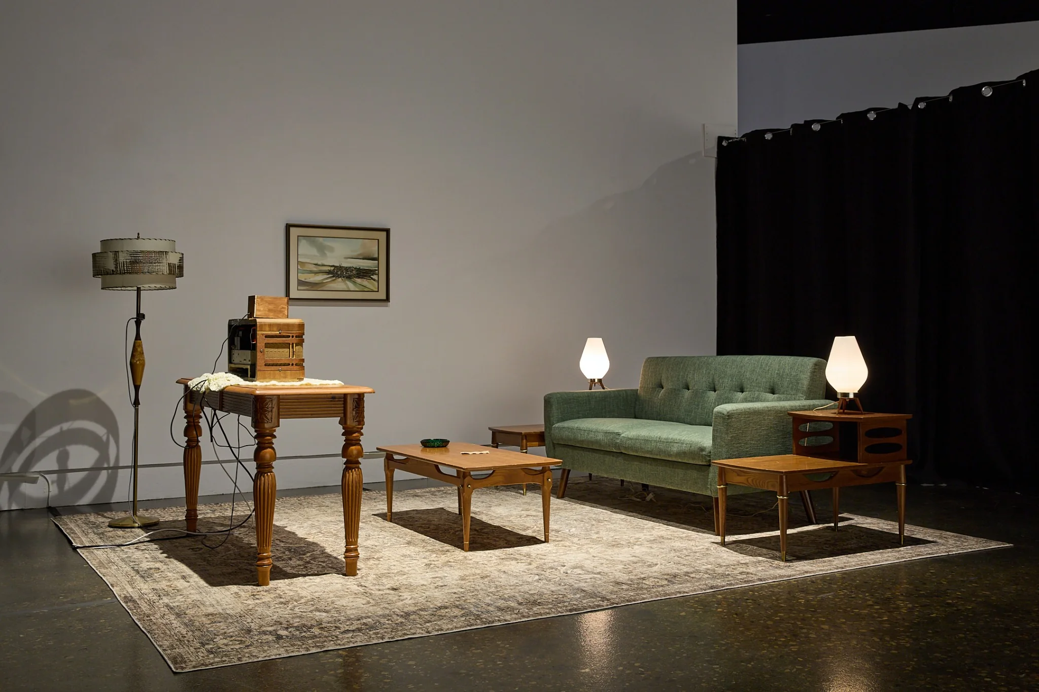Installation view of a furnished mid-century living room containing the Victory Box